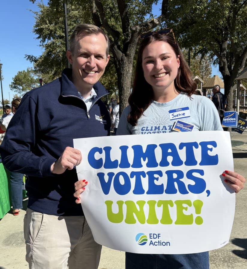 Two people holding a "Climate Voters, Unite" sign